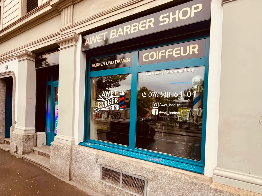 Das Schaufenster von Awet Barber Shop mit türkisem Rahmen und goldener Schrift